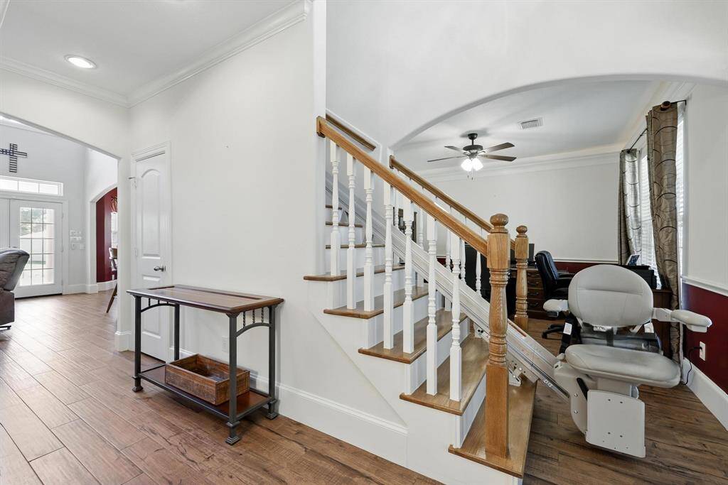 The entryway highlights a beautiful stairway leading to the second-floor bedrooms and baths. Wood-look tile flooring extends throughout the entire first floor, combining style with durability. Please note, the chairlift is scheduled to remain with the seller unless the buyer expresses interest in retaining it