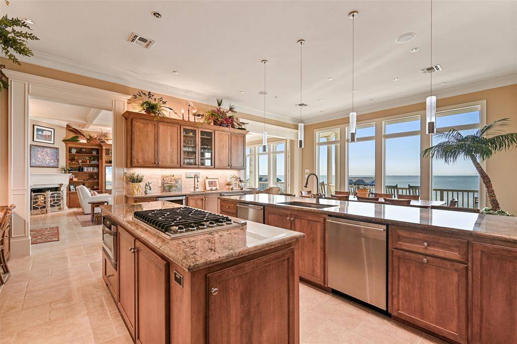 The kitchen boasts granite countertops, tons of cabinetry, and a wet bar both a built in wine and beverage cooler.