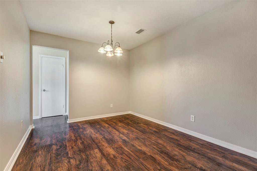 A full view of the dining area, with easy access to the kitchen through the open doorway and a convenient pantry tucked behind the closed door.