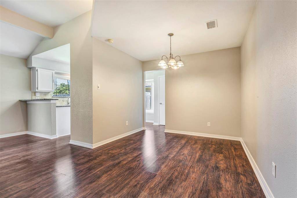 The kitchen and dining area sit side by side, separated by a partial wall that creates a semi-open layout—offering both connection and defined spaces.