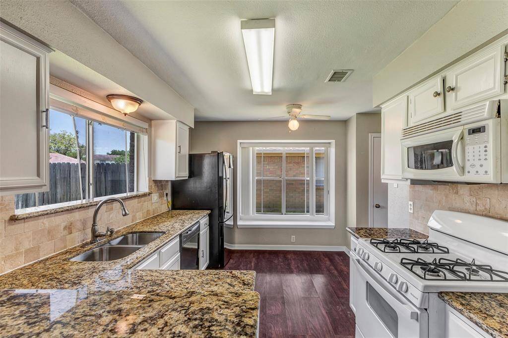 The kitchen features a large glass window by the sink, offering a lovely view of the backyard while you cook.
