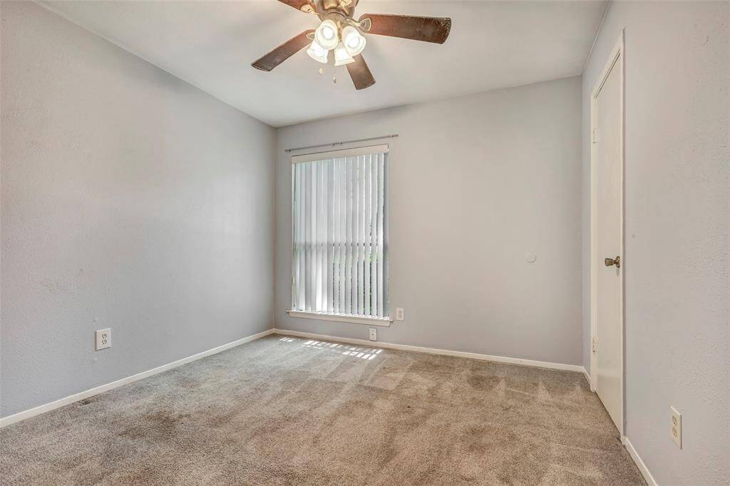 This secondary bedroom overlooks the front lawn and includes a walk-in closet, providing ample storage space.