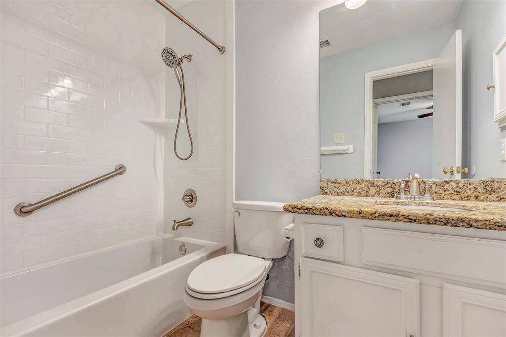 The shared bathroom between the secondary bedrooms features a tub and shower combo, a single sink, and a large vanity mirror, combining practicality with comfort.