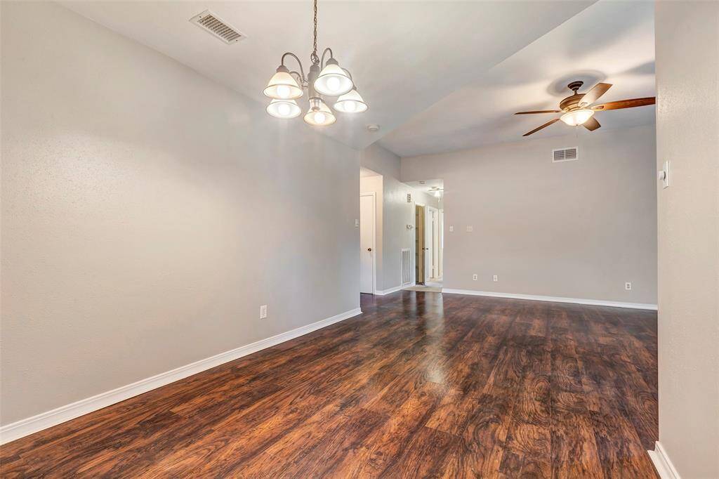A beautiful chandelier adds a touch of elegance to the dining room, creating a warm and inviting atmosphere.