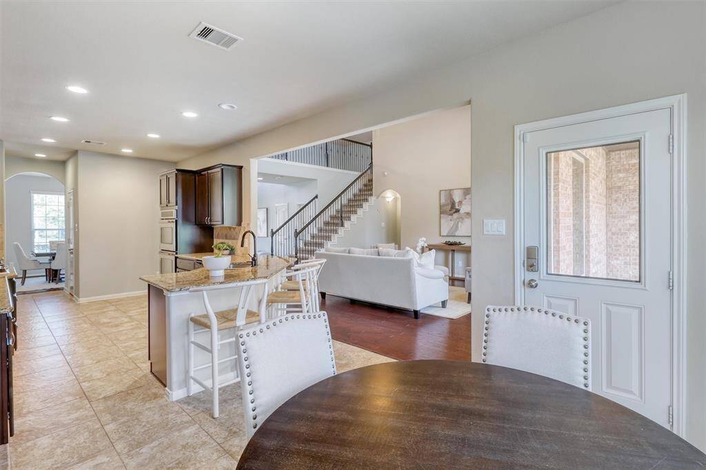 This open-concept view perfectly captures the heart of the home—blending kitchen, breakfast, and family room spaces into one cohesive and welcoming gathering area.