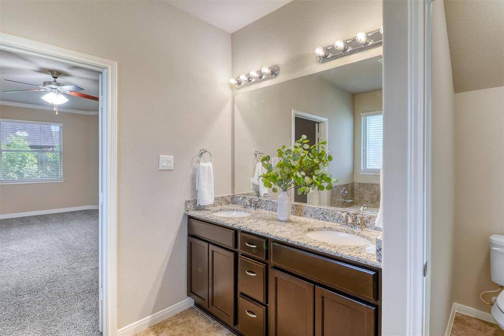 Enjoy a moment of calm as natural light pours into the ensuite from the privacy glass window, highlighting the polished finishes and sleek cabinetry.