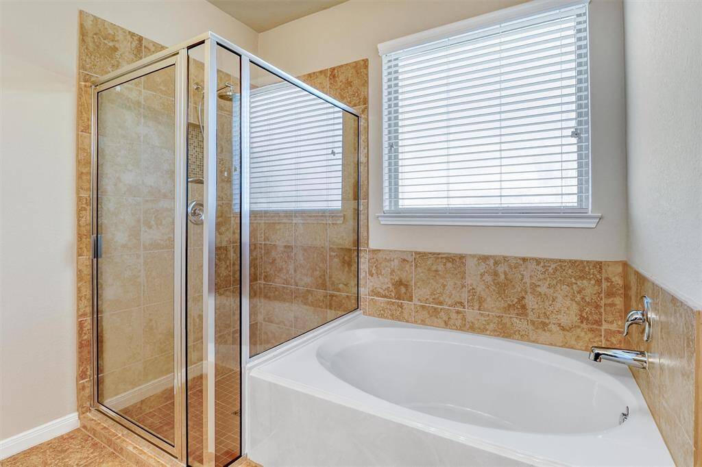 Indulge in a relaxing soak or refresh under the separate tiled walk-in shower—the best of both worlds for your personal spa experience.