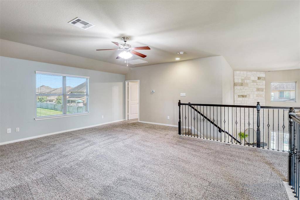 With plush carpeting and natural light pouring through the window, this spacious game room is perfect for entertaining or everyday relaxation.