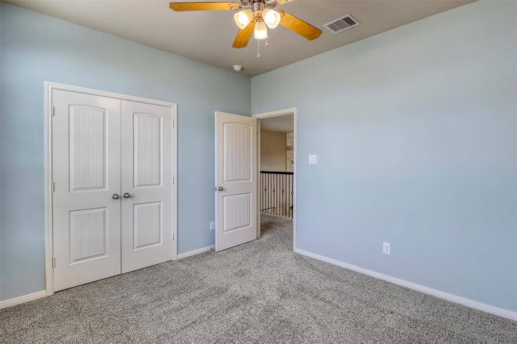 A generous double-door closet offers great storage, while soft hues and plush carpet create a calming space in this lovely guest bedroom.