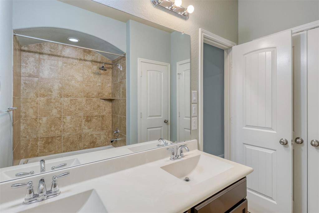 Conveniently located between both rooms, this shared bathroom is finished in soothing tones and modern touches.