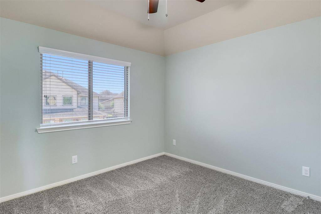 Large windows bring in ample natural light, making the fourth bedroom feel airy and bright.