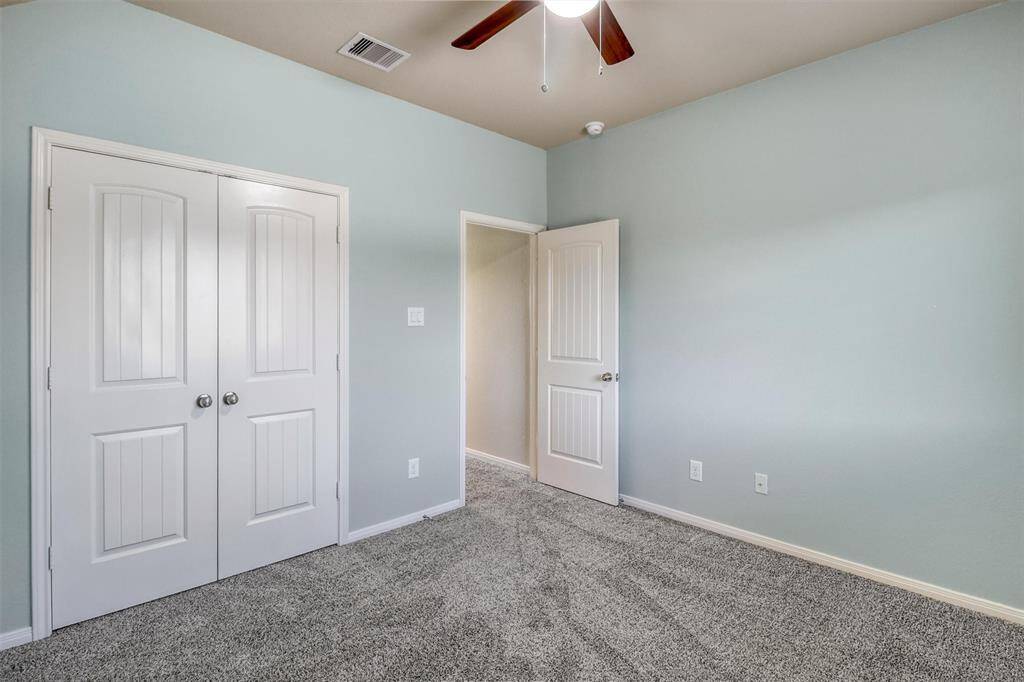 This spacious secondary bedroom also features a deep double-door closet and cool neutral tones to suit any style.