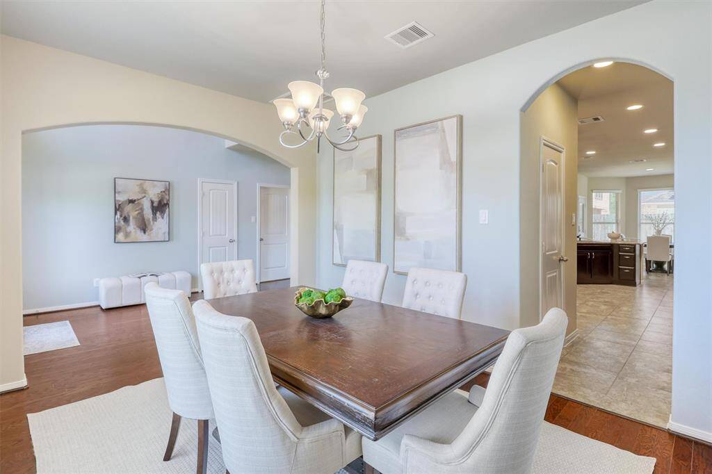 The formal dining room offers generous dimensions and natural light from front-facing windows, with easy access to the kitchen through an arched doorway—ideal for both entertaining and everyday living.