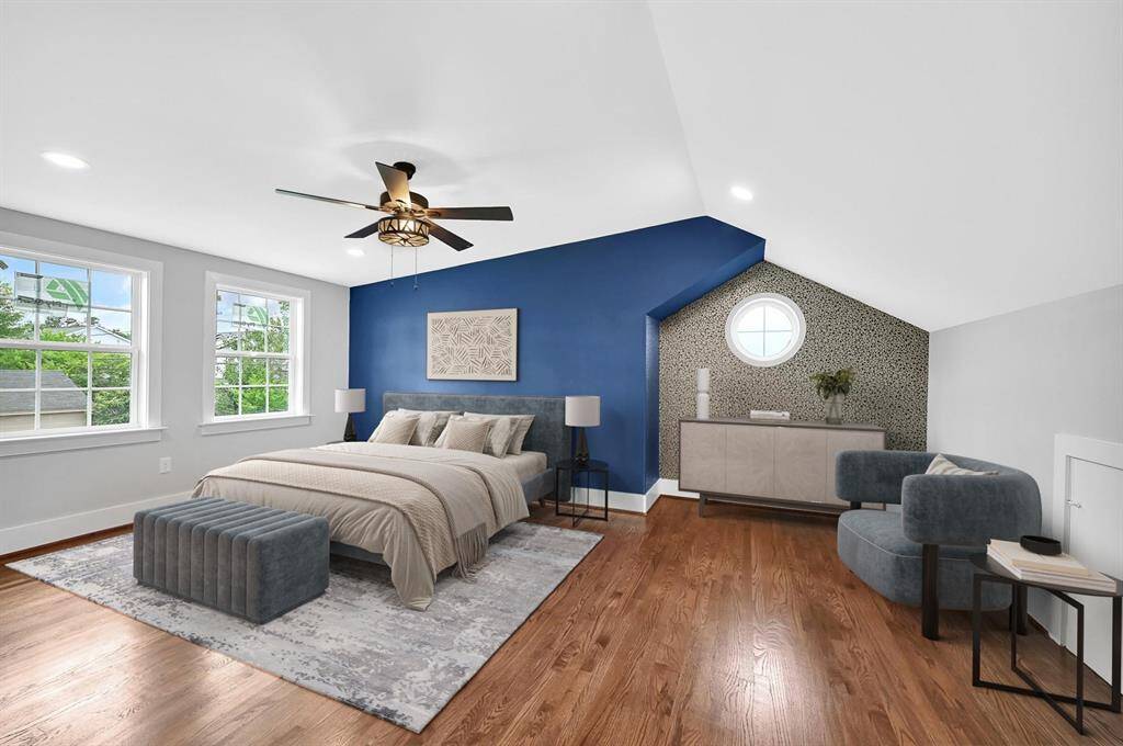 This spacious bedroom boasts multiple windows for natural light, a striking custom accent wall, and a ceiling fan for added comfort, creating a perfect retreat. *Virtually Staged*