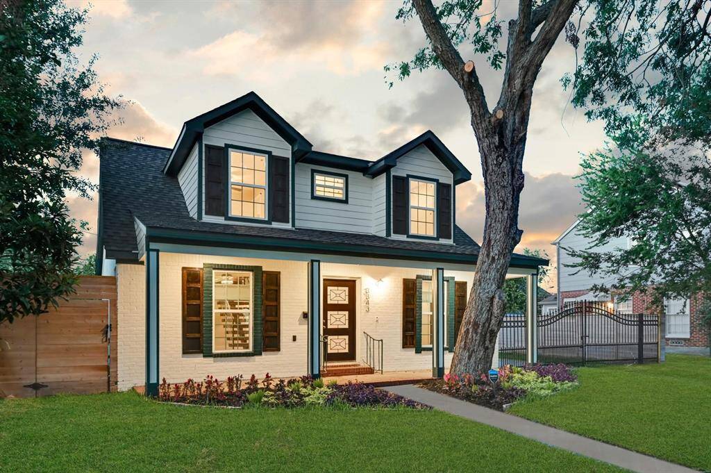Enjoy outdoor living on the expansive front patio deck, beautifully complemented by lush landscaping, a mature shade tree, and a well-maintained lawn—perfect for relaxing or entertaining in style.