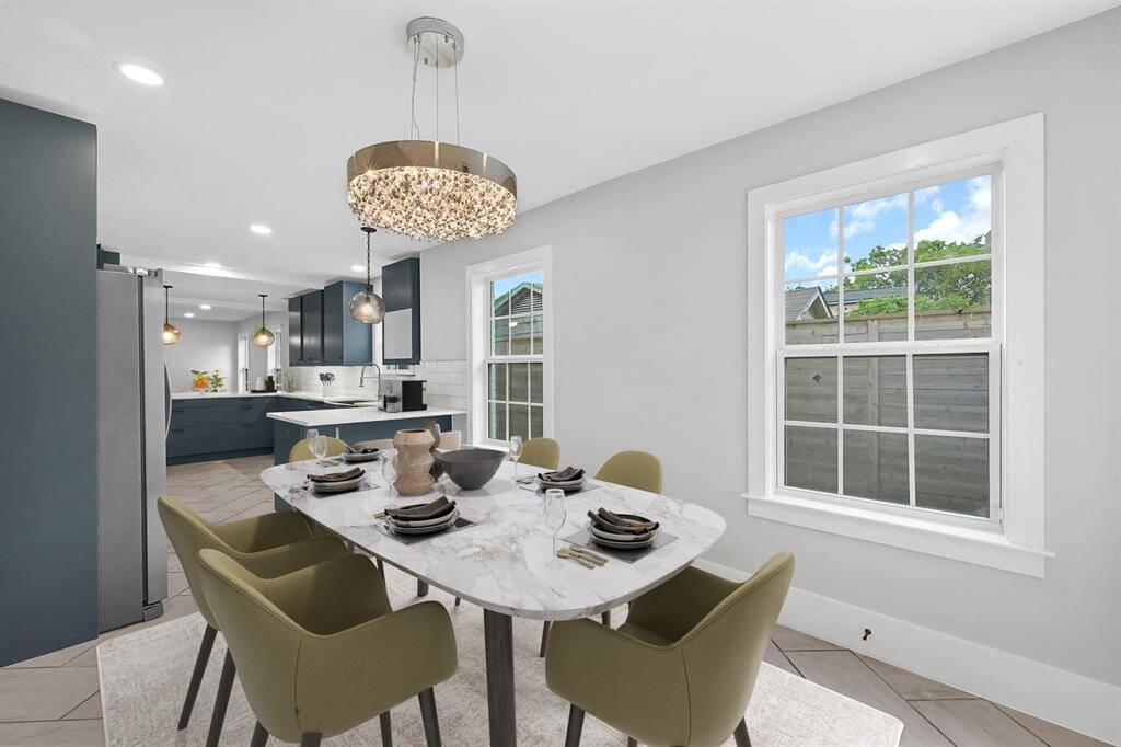 The charming breakfast nook, conveniently located next to the kitchen, features multiple windows that fill the space with natural light, custom paint for a stylish touch, and a modern chandelier that adds elegance to your morning routine. *Virtually Staged*