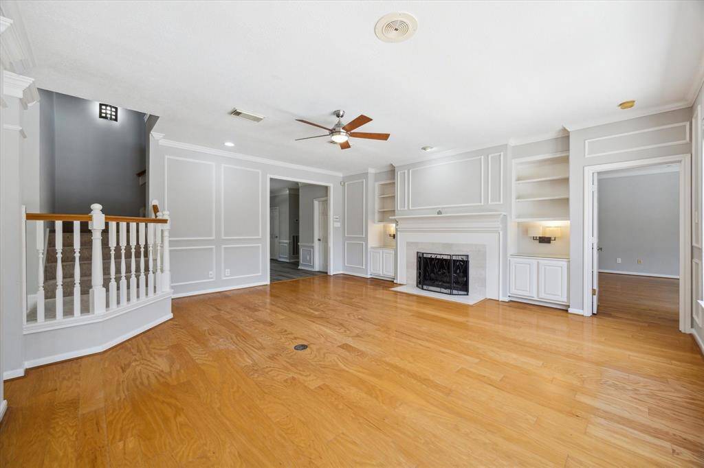 With serene views of the sparkling pool just beyond a wall of windows, this family room is a true retreat. The open layout invites you to unwind in comfort, with a cozy gas fireplace, cooling ceiling fan, and plenty of space to arrange your favorite furnishings just the way you like.