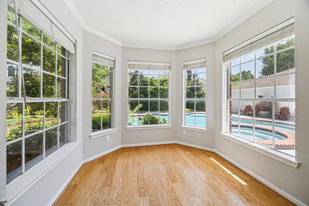 This serene primary suite offers a peaceful retreat with beautiful hardwood floors, soft neutral tones, and a charming bay window that fills the space with natural light. Enjoy direct access to the patio and pool through a private glass door, along with a custom walk-in closet and a luxurious ensuite bathroom for added comfort and convenience.