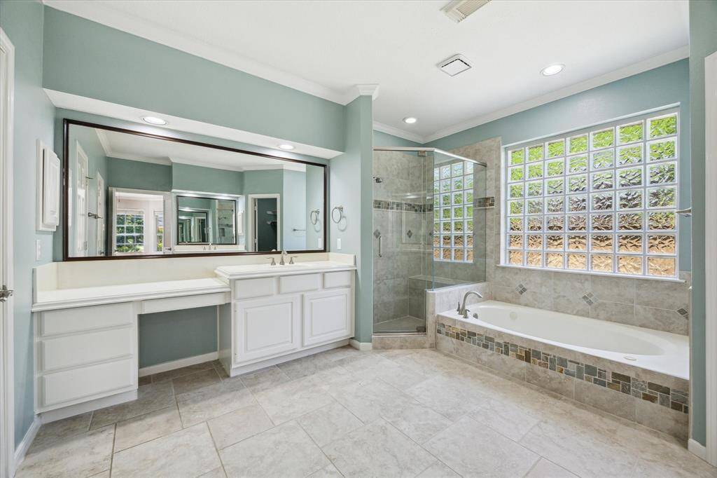 This luxurious ensuite bathroom has everything you need to unwind in comfort or start your day refreshed. Enjoy dual vanities, a deep jetted tub, a fully tiled walk-in shower, and access to a spacious walk-in closet—all wrapped in a serene, spa-like setting.