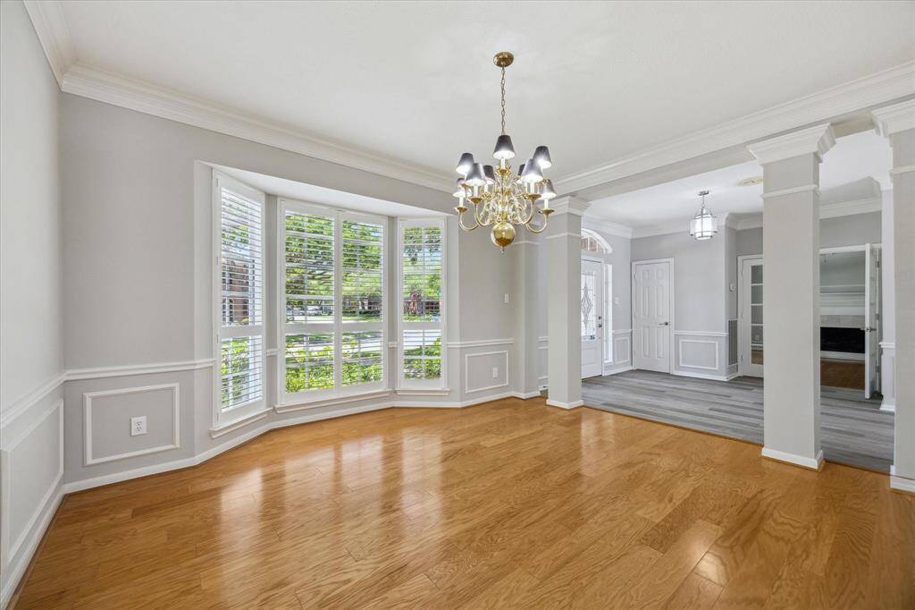 This grand formal dining room offers the perfect setting for both lavish dinner parties and casual family gatherings. Features include hardwood floors, fresh neutral paint, chair rail, picture and crown molding, a stylish chandelier, and bay windows with wood shutters that frame picture-perfect views of the front yard.