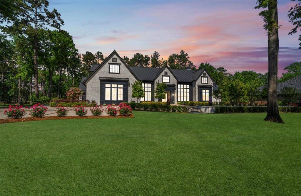 This elegant home features a grand entrance with large windows that provide ample natural light, and the surrounding landscaped garden enhances the inviting atmosphere.