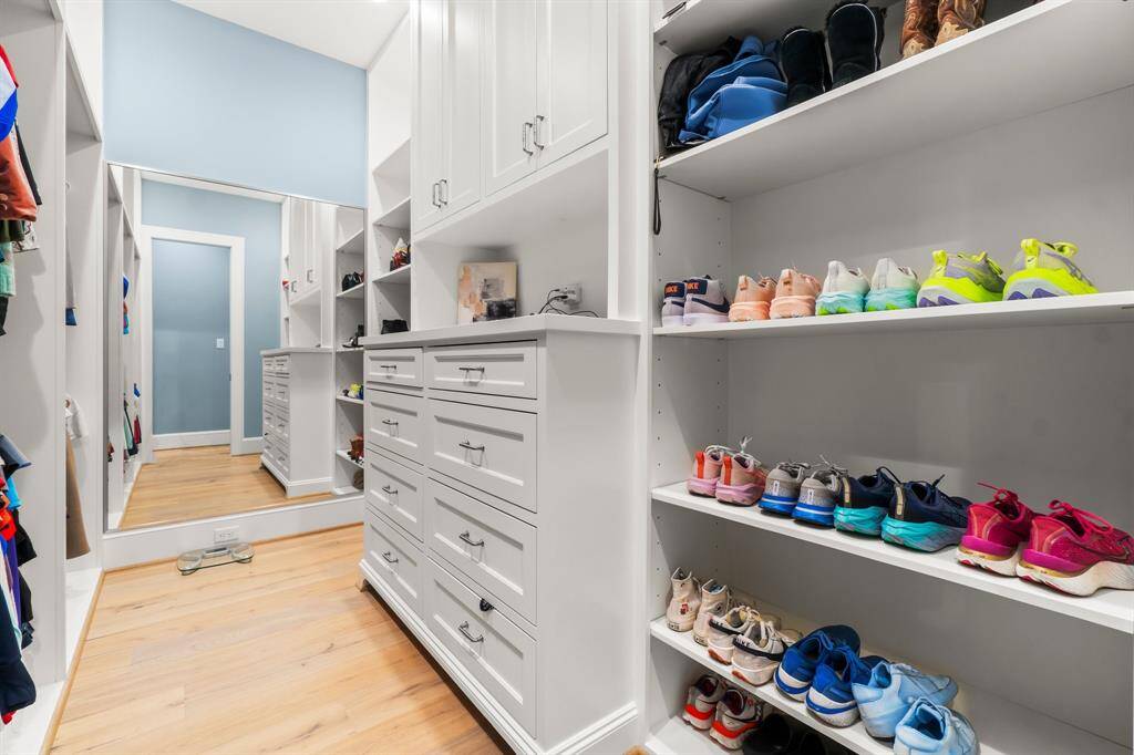 Spacious, walk-in closet featuring ample shelving for shoes, abundant drawer storage, and hanging space for clothing.