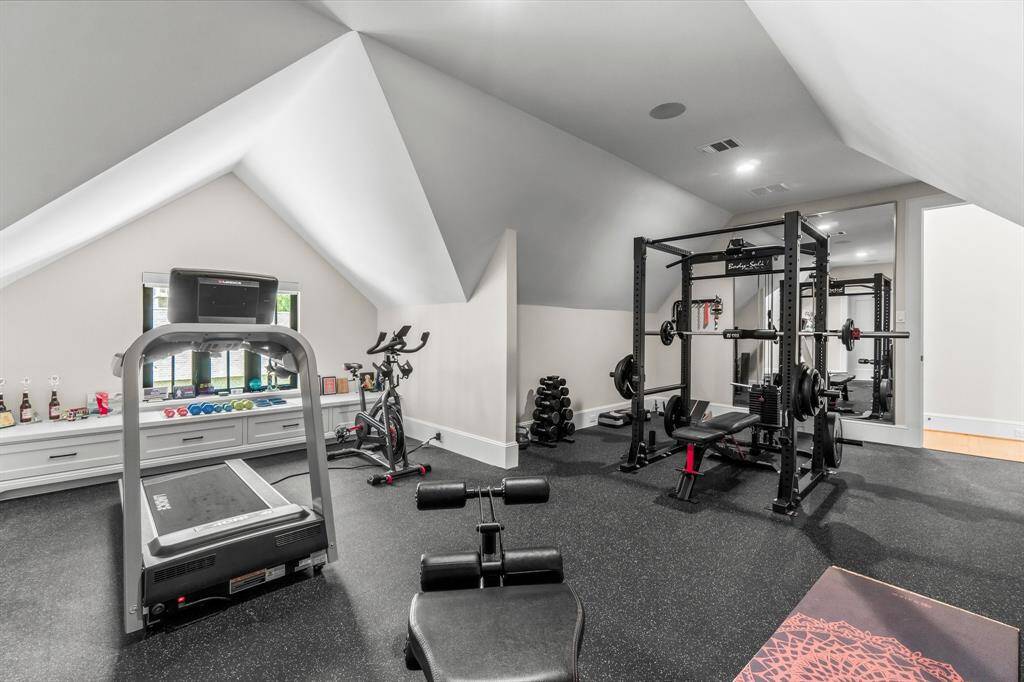 The room has sloped ceilings, a large mirror, and built-in storage, creating a functional and stylish area.