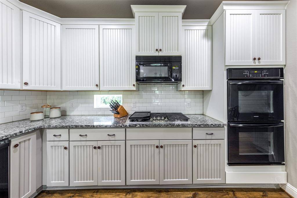Double ovens and built-in microwave. 32” 5 burner gas cooktop with cast iron griddle.