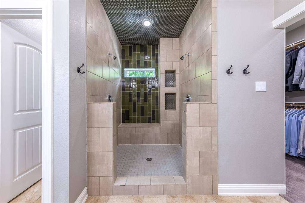 Custom oversized shower with dual shower heads, custom tile floor to ceiling.