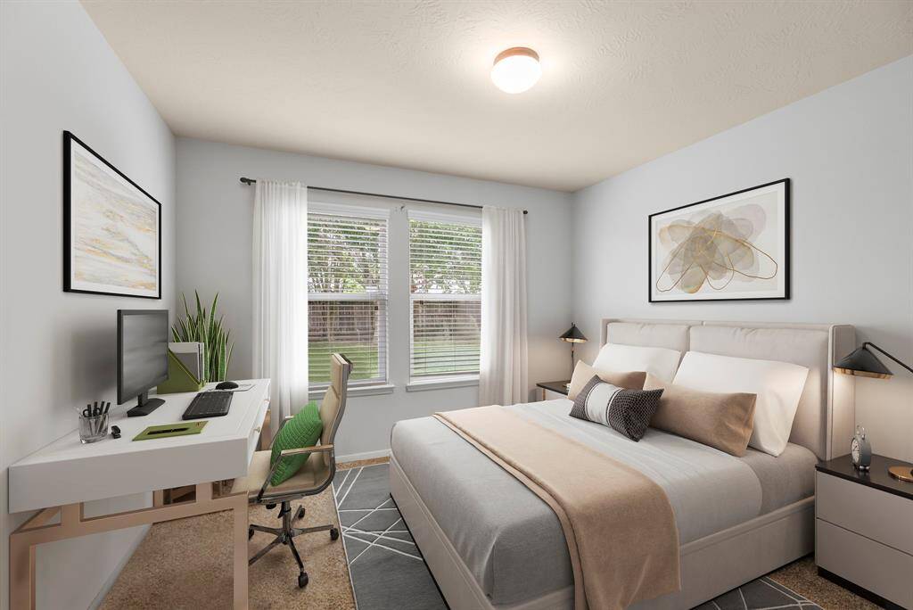 The downstairs secondary bedroom features plush carpet, bright natural light, neutral paint, and a spacious closet. It's nestled at the back of the home looking out to the serene back yard. *This room has been virtually staged