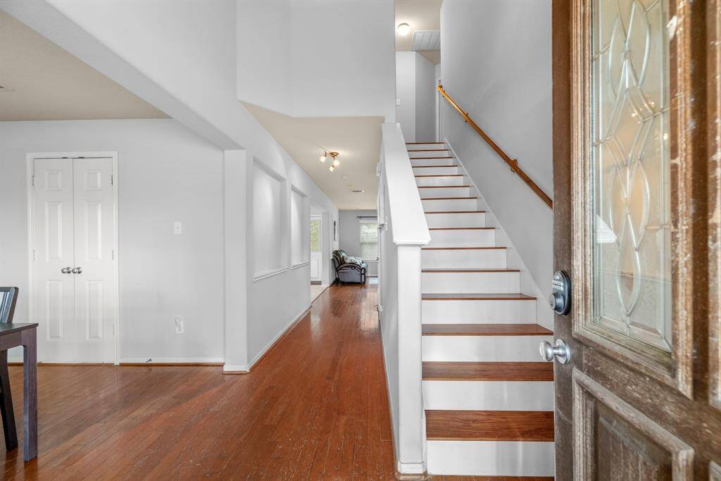 Walking in, you find a bright entryway with high ceilings and warm wood flooring that continues into the main living areas making it easy to clean and maintain. To the left you have a formal dining room or bonus space, perfect for eating in, a library, or study!