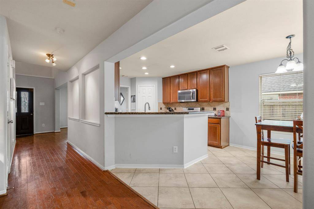 The heart of the home! This spacious kitchen features wood cabinetry, plenty of counter space, sleek stainless steel appliances, and a bartop for additional seating—perfect for gathering and entertaining.