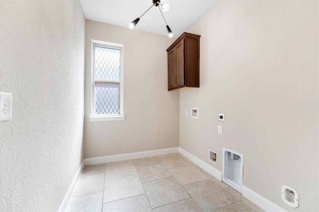 Right off the Primary Closet so conveniently located is the laundry room. Plumbing and electrical hookups are visible, suitable for a washer and dryer.