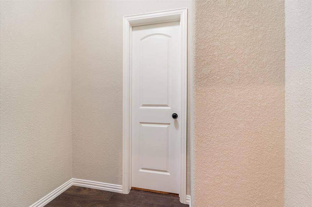 Right off the hallway, this quaint space can be used as a flex/closet and leads directly to the already conditioned attic. The walls are painted in neutral tones, and the flooring is a dark wood finish, creating a clean and classic look.