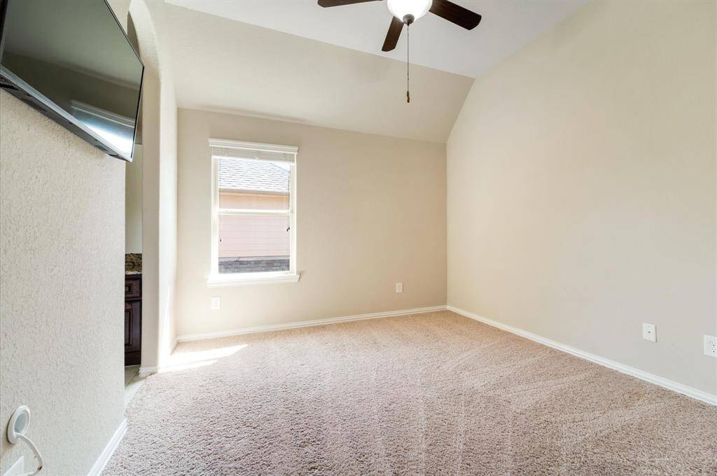 the other secondary bedroom room with a ceiling fan and natural light from a window. Neutral walls provide a blank canvas.