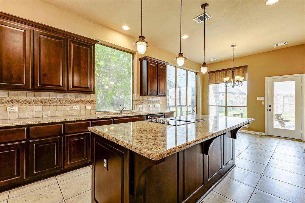 granite countertops, and a large central island with pendant lighting.