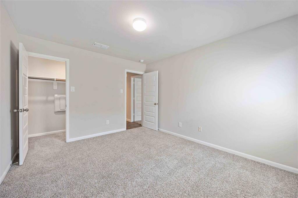 Empty space, ready for personalization, in a secondary bedroom with a clean, modern aesthetic.