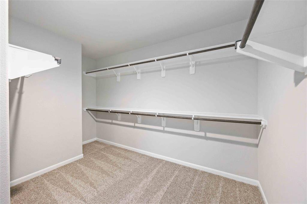 Pristine, organized, and ready to hold treasures. A walk-in closet, impeccably designed for effortless storage.