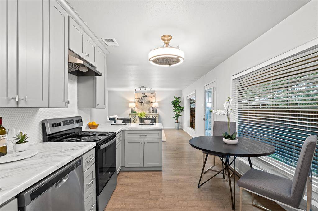 Elegant lighting joins abundant natural light to illuminate this well-appointed kitchen.
