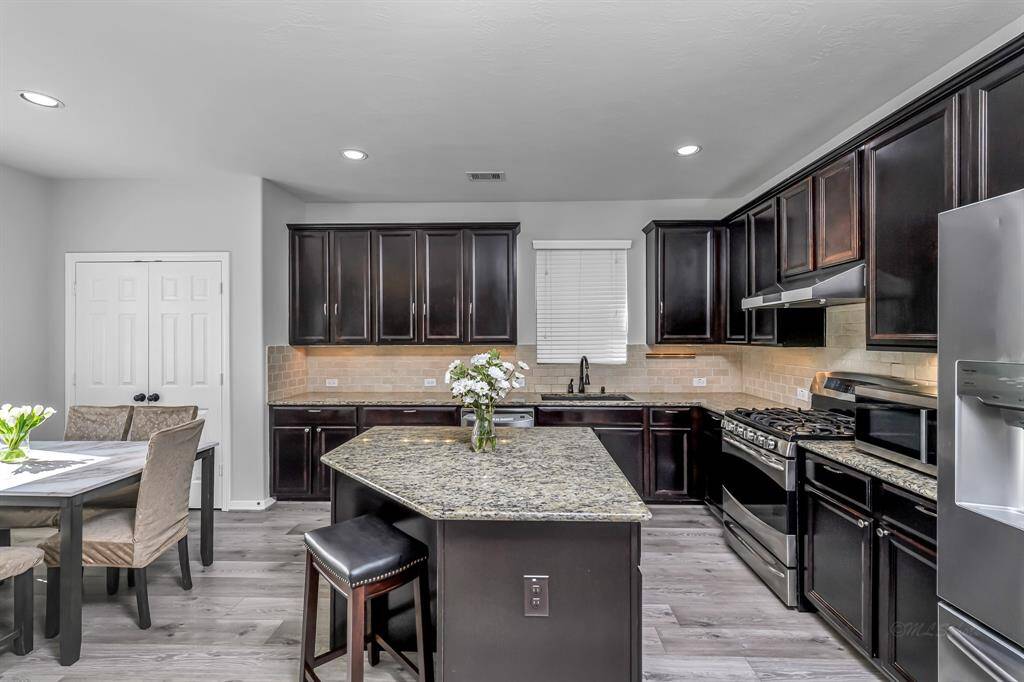 Additional seating at island, recessed lighting and stainless steel appliances