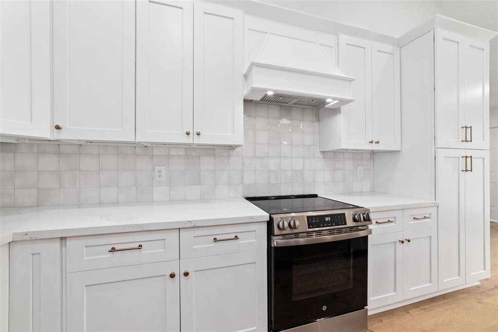 Modern kitchen featuring sleek, BRAND NEW stainless steel appliances and elegant quartz countertops.
