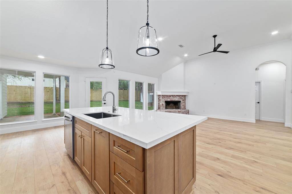 Open kitchen seamlessly flows into the family room, highlighting a cozy fireplace.