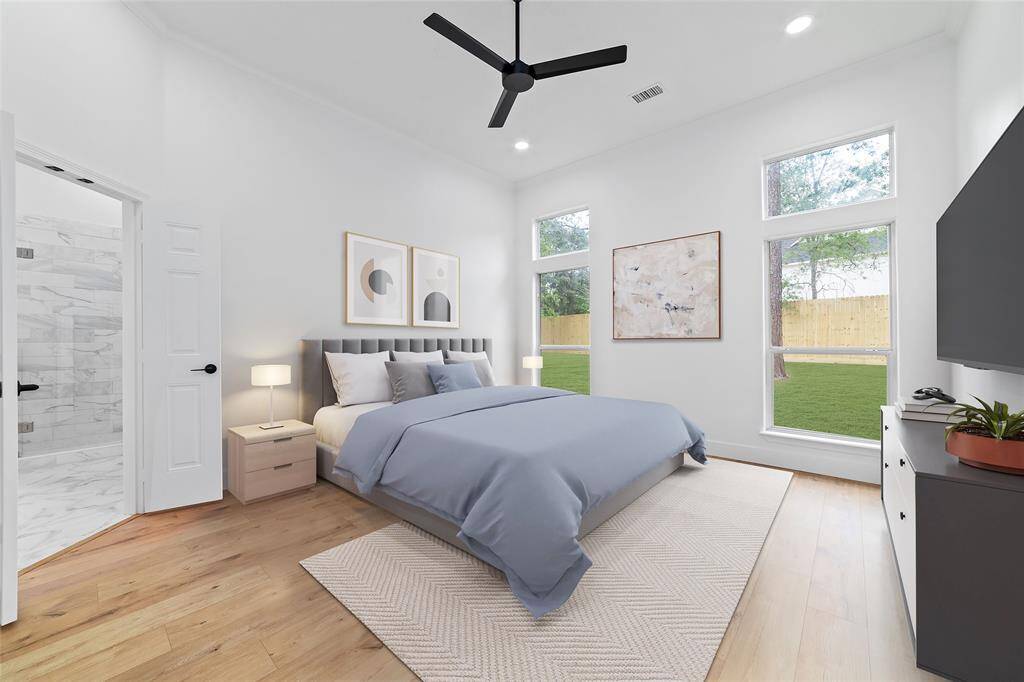 Primary bedroom overlooks the back yard and features a ceiling fan, recessed lighting, and new flooring.  *virtually staged*