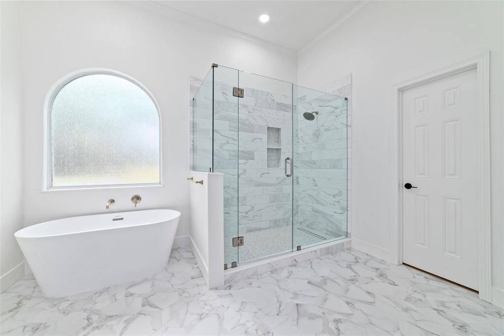 Luxurious primary bath featuring a relaxing soaking tub and spacious walk-in shower.