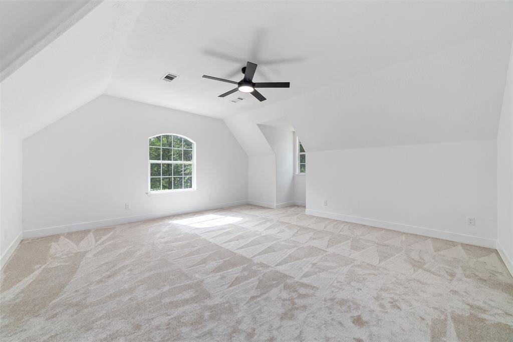 Upstairs game room with plush carpeting and charming dormer windows.