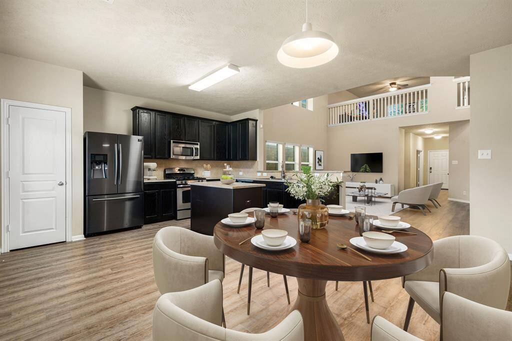 This lovely breakfast area is perfect for starting the day out on the right foot.  This space showcases custom paint, high ceilings, hanging pendant light, recessed lighting, large window adding to the ample natural light in the kitchen, beautiful chair rail and molding and wood style flooring. *Virtually Staged