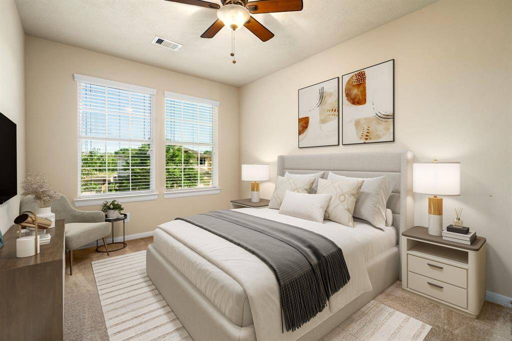 Secondary bedroom great for use as an in-law suite or guest suite features high ceilings, lovely modern ceiling fan, custom paint, plush carpet, space for seating area, direct access to the secondary bathroom and large window with privacy blinds. *Virtually Staged