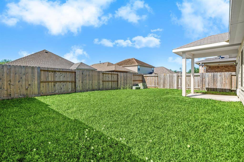 Expansive fenced-in backyard offering plenty of space for play, pets, or entertaining.
