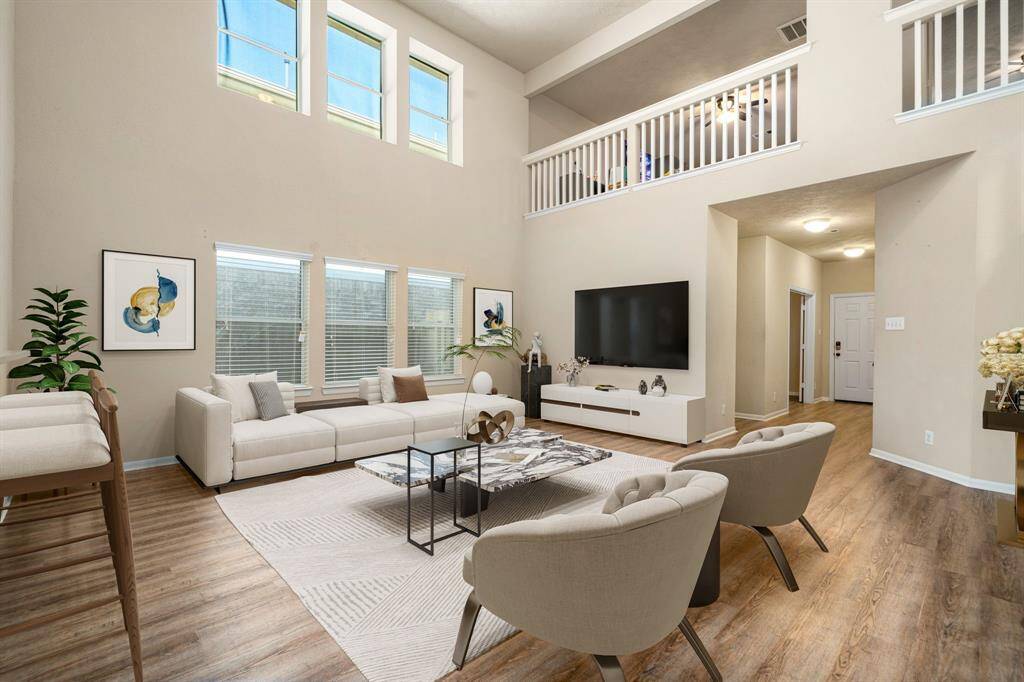 Gather the family and guests together in your lovely living room! Featuring soaring high ceilings, recessed lighting, dark stained ceiling fan, custom paint, gorgeous wood stlye floors and large windows that provide plenty of natural lighting throughout the day. *Virtually Staged