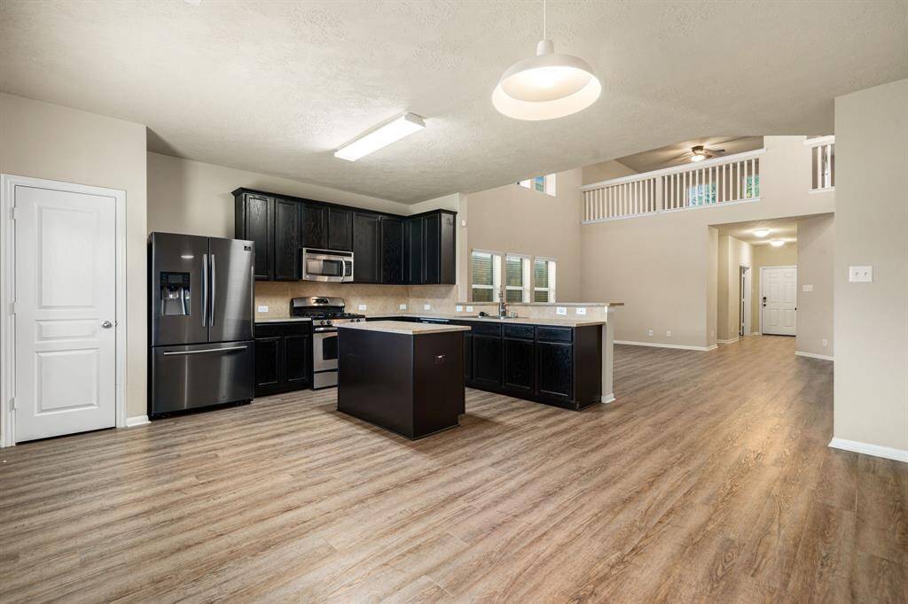 This kitchen is by far any chef’s dream! This spacious kitchen features large windows, high ceilings, dark stained wood cabinets, granite countertops, SS appliances, modern tile backsplash, recessed lighting with additional custom pendant lighting, extended counter space, granite kitchen island with double sink and space for breakfast bar and a walk-in pantry all overlooking your huge family room.